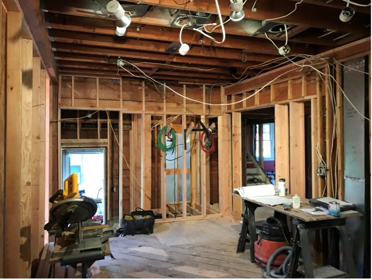 A room that is being remodeled with a table saw and a vacuum cleaner.