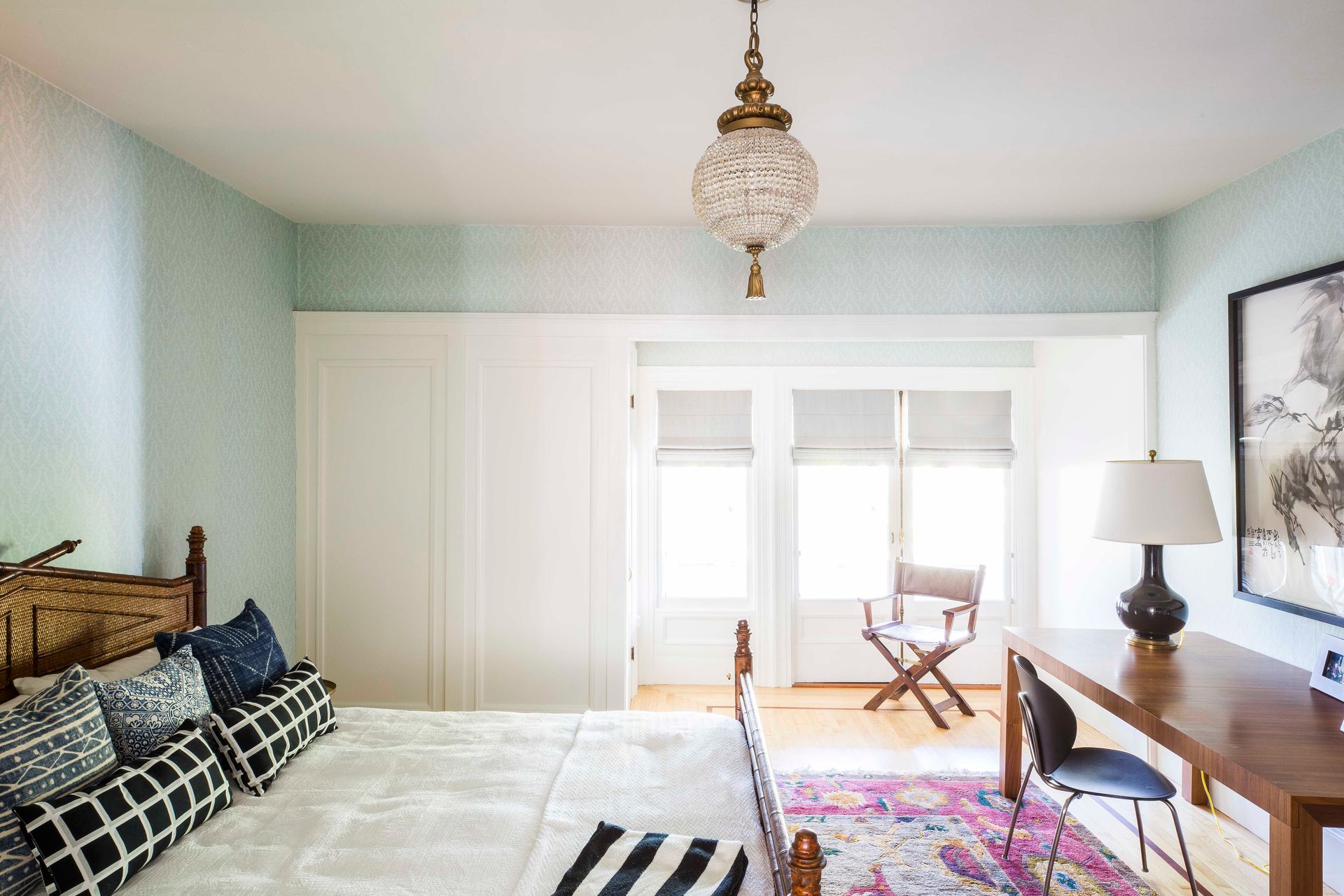 Guest room bathed in natural light from the original windows was once a maid's quarters. In the paneled corner there is a petite WC.