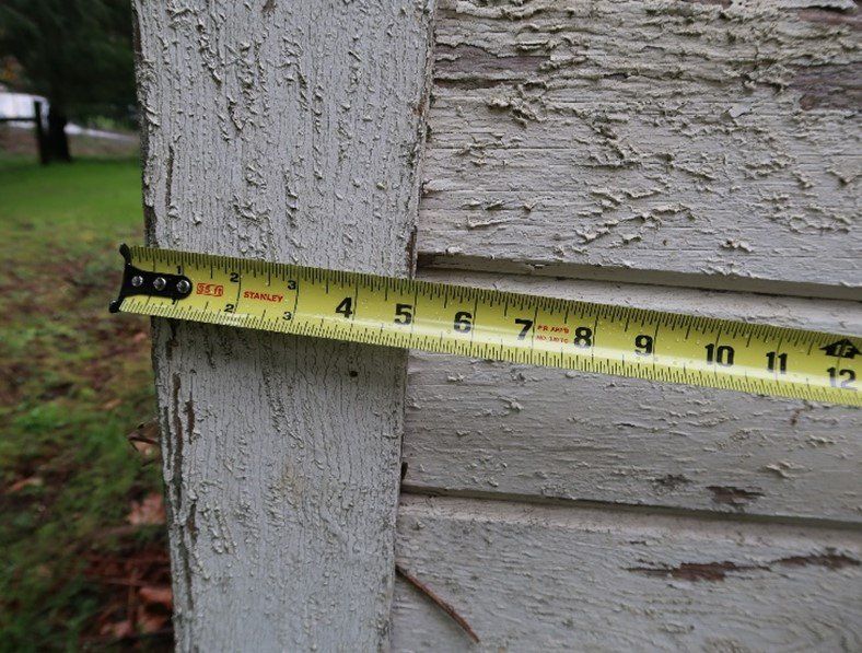 A tape measure is being used to measure a piece of wood