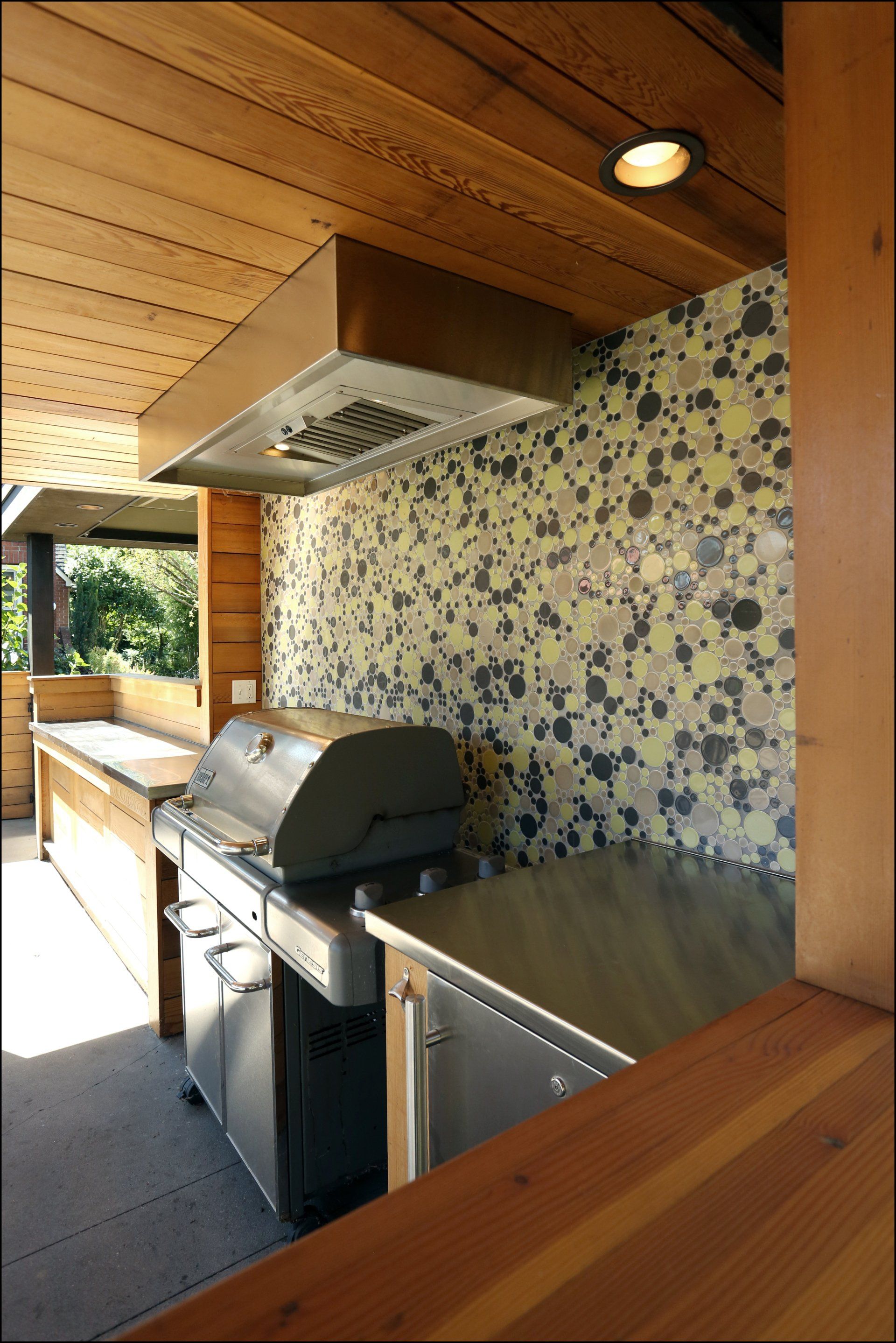 The outdoor kitchen has a playful Clayhaus backsplash made of varying sizes of circles
