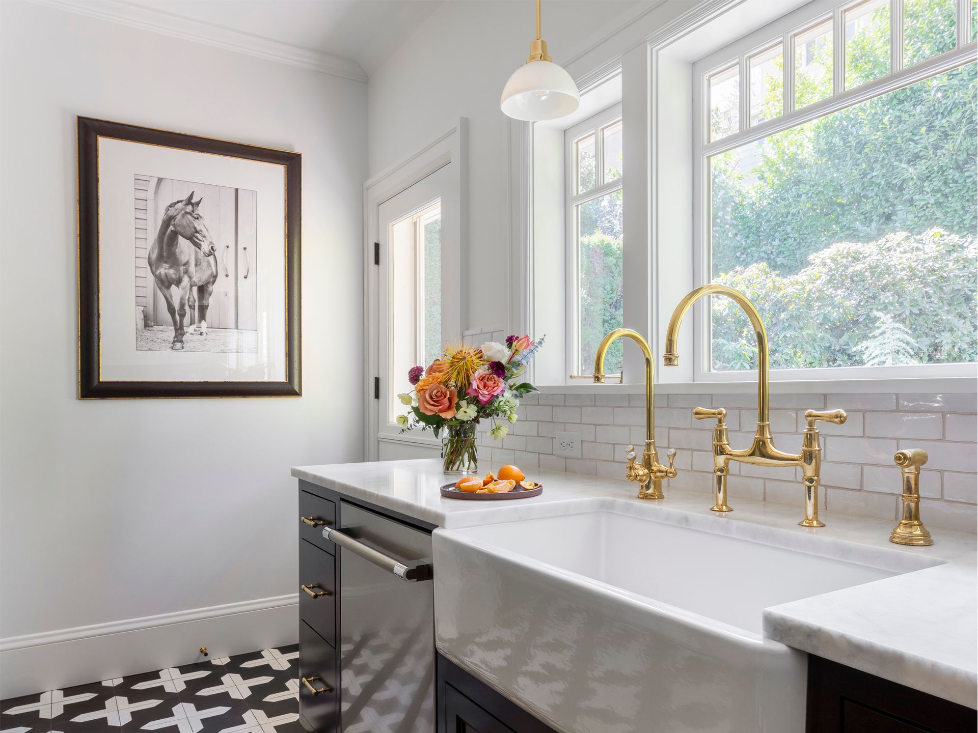 Daylight spills into the kitchen from the back windows, at the sink wall.