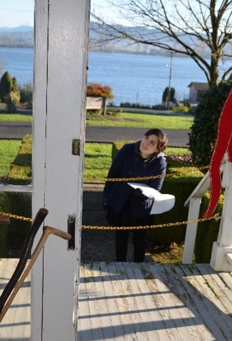 A woman standing on a porch looking out over a body of water