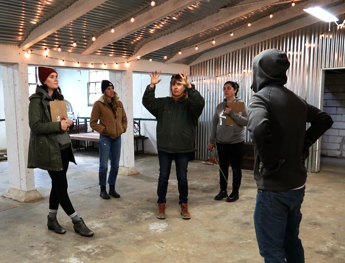 A group of people are standing in a room talking to each other.