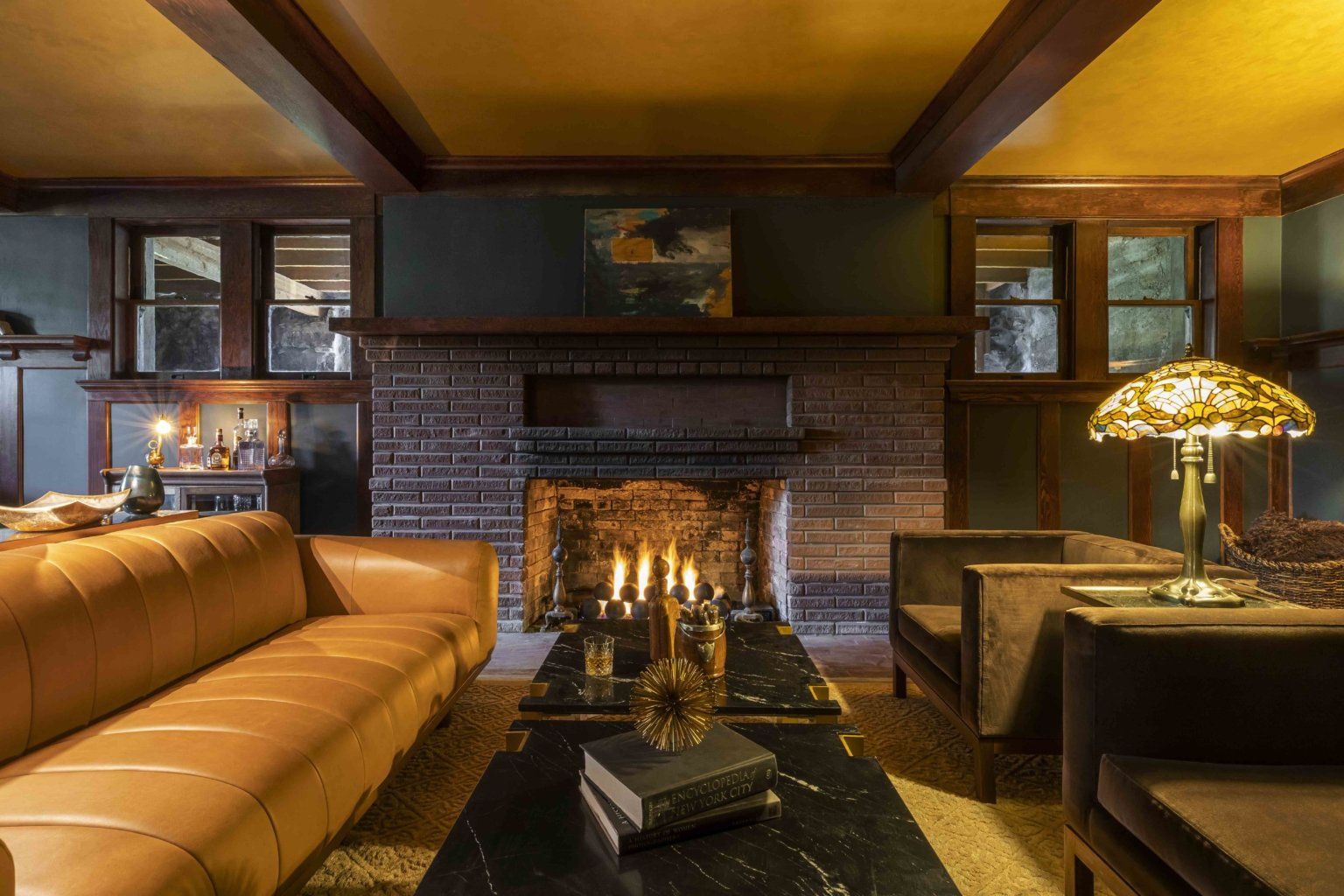 The clubby basement is inviting with plush furniture next to the original fireplace - a great place to gather and unwind.