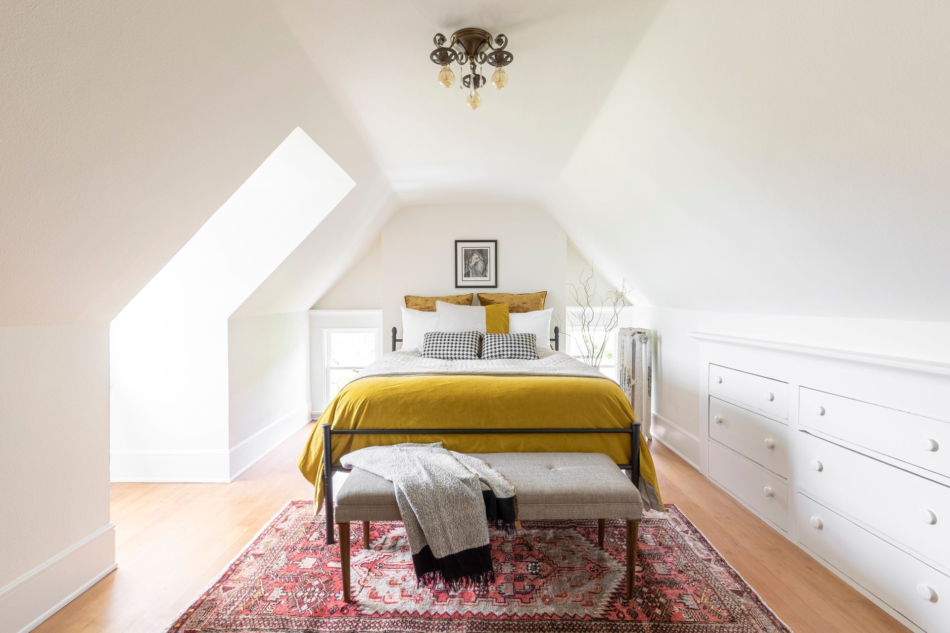 Double eaves frame the bed in this light-bathed second floor bedroom.