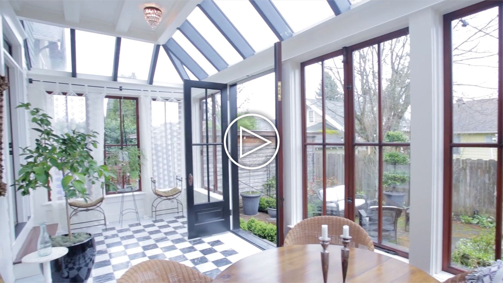 A sunroom with a table and chairs and a checkered floor.