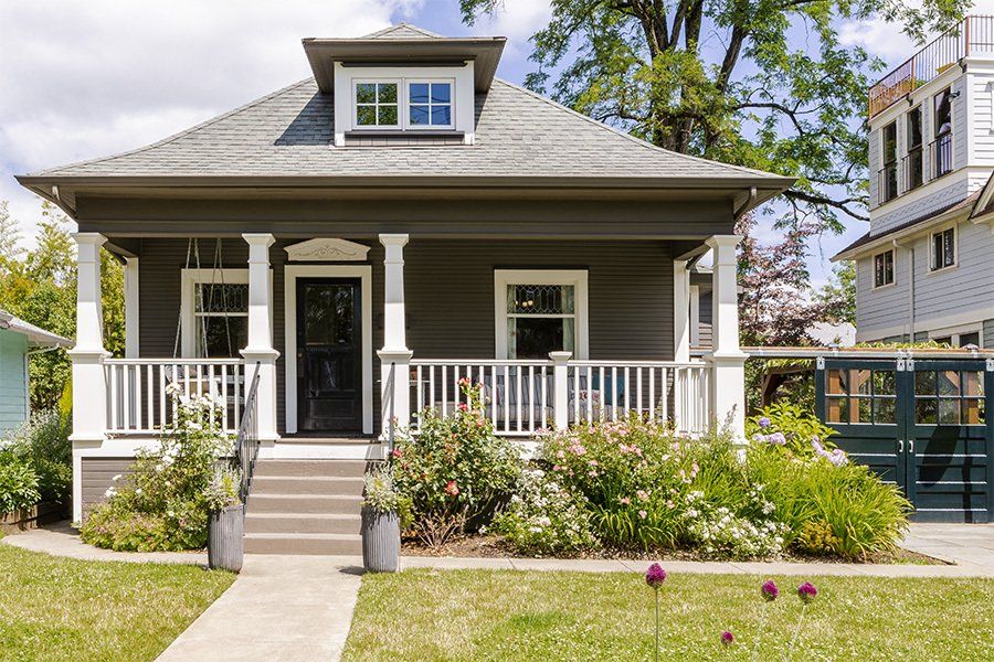 A small house with a porch and a walkway in front of it.