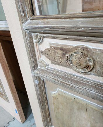 A close up of a wooden door with a mirror on it.