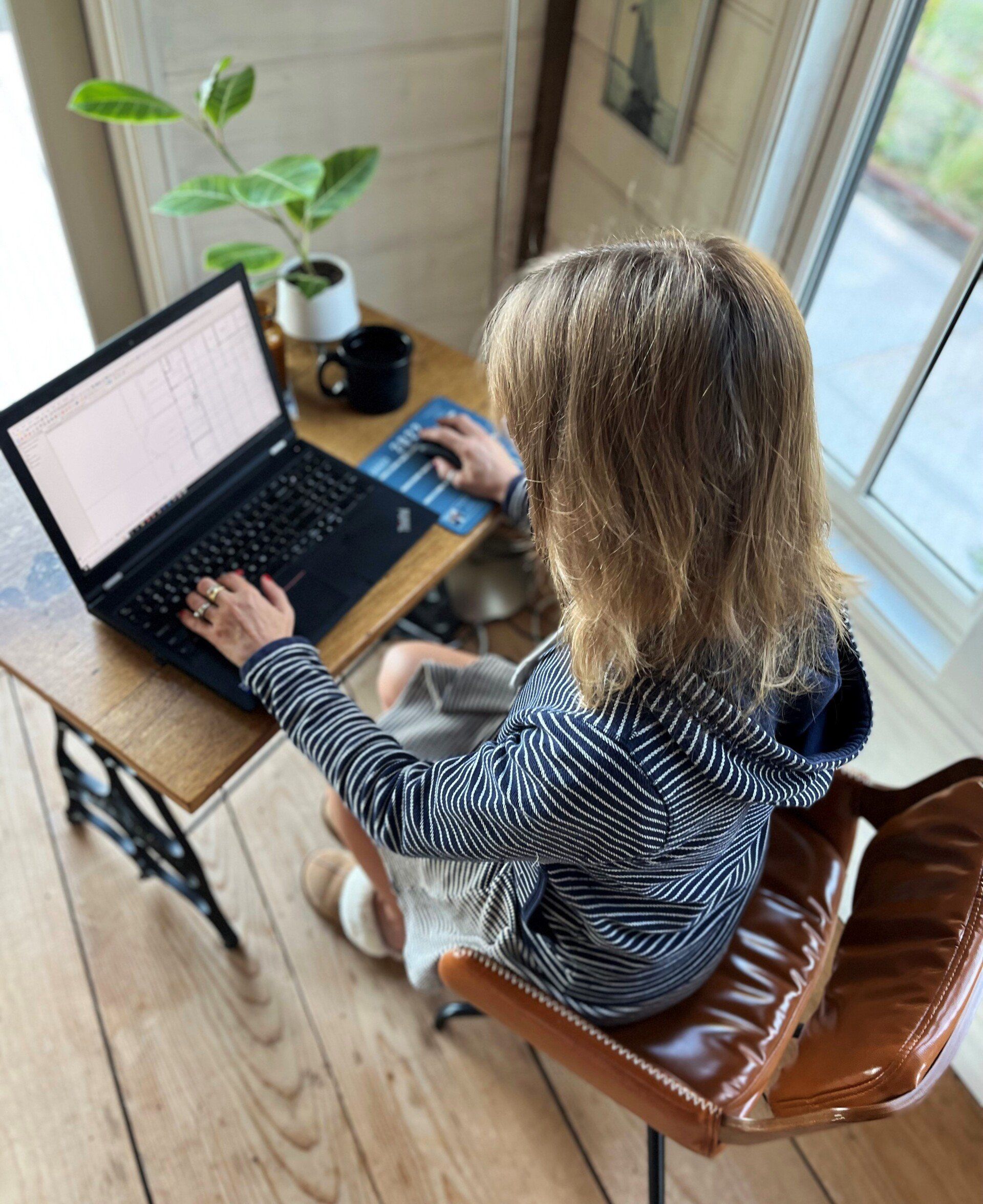 A little girl is typing on a laptop computer