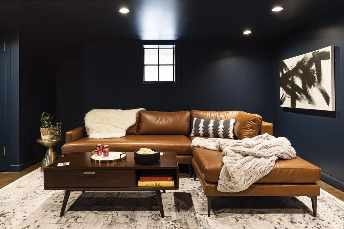 A living room with a brown leather couch and a coffee table.