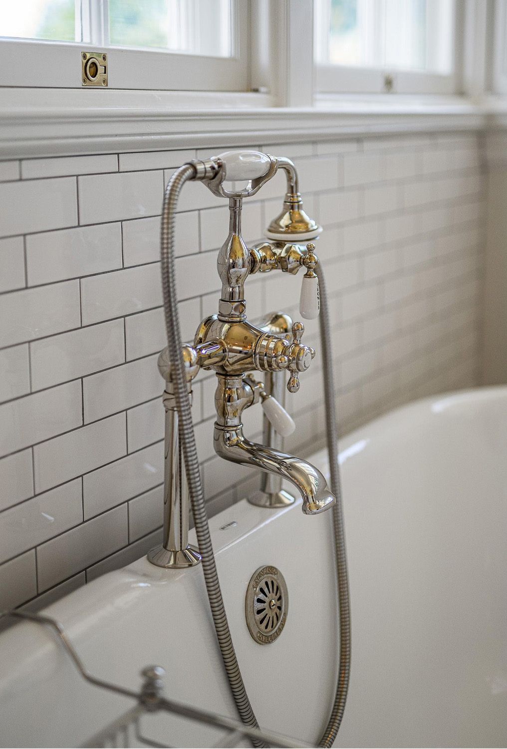 1916 Irvington Colonial Revival primary bathroom with vintage nickel tub faucet