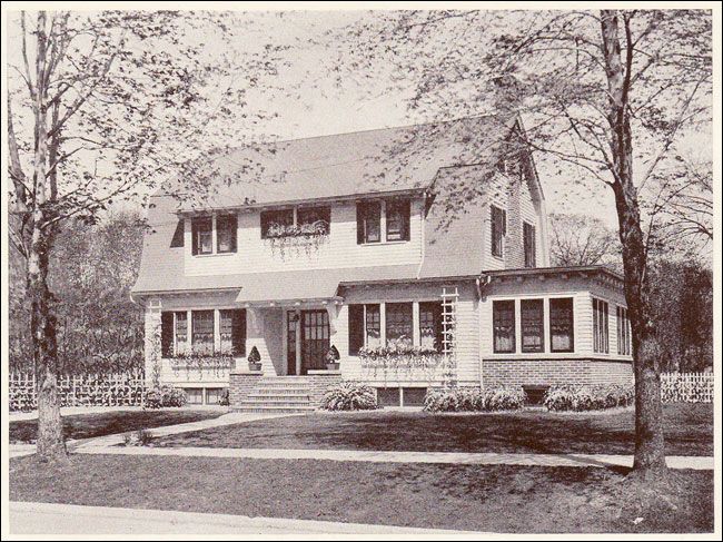 Sepia-toned historic house with front porch, gabled roof, and trees in the yard