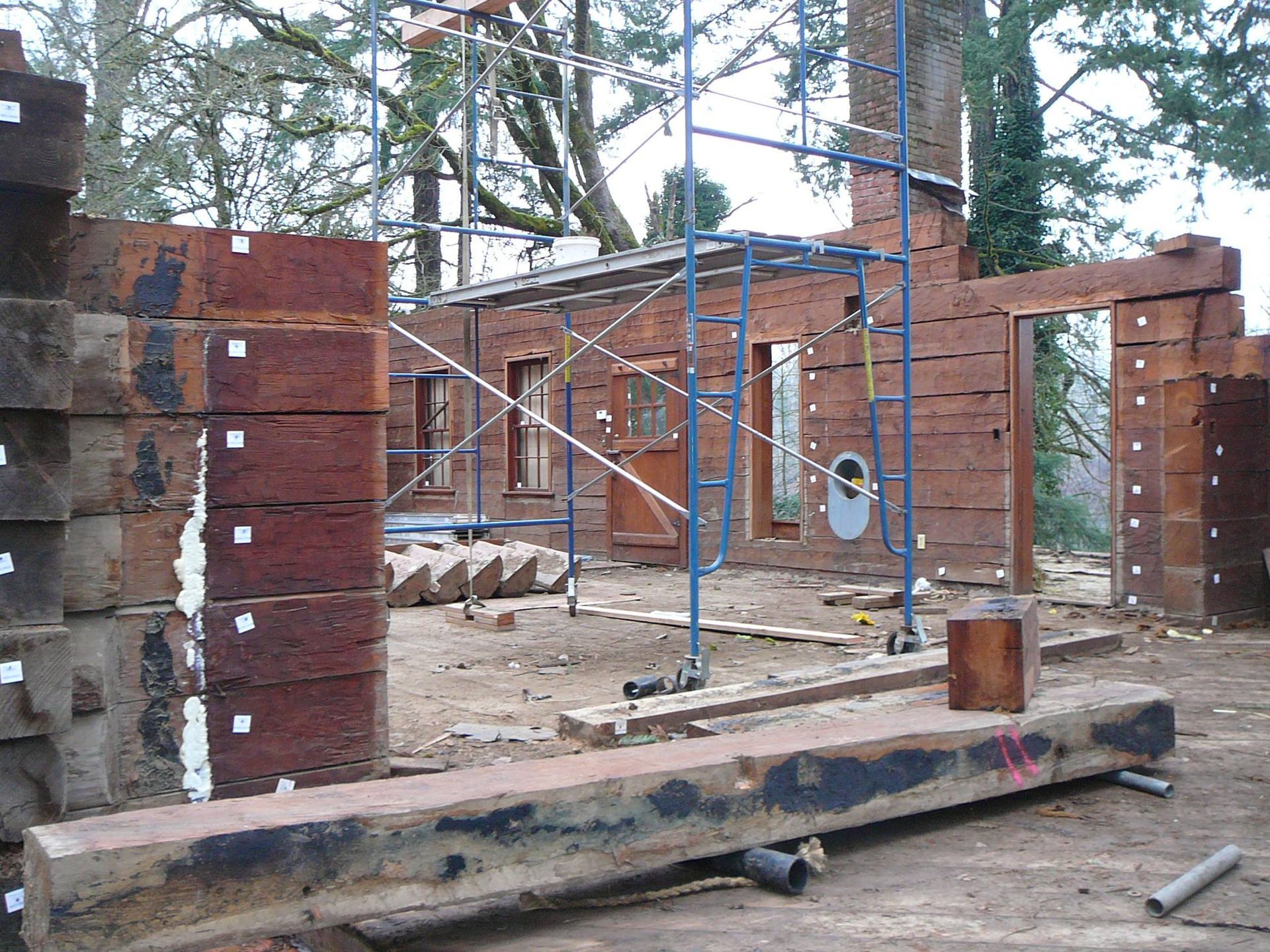 Partially built brick structure with scaffolding and construction debris outdoors