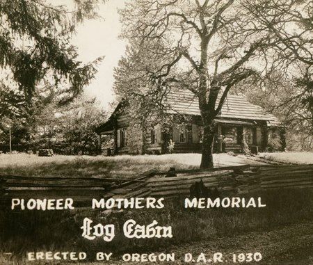 Sepia photo of Pioneer Mothers Memorial log cabin in a wooded setting, erected by Oregon D.A.R. 1930