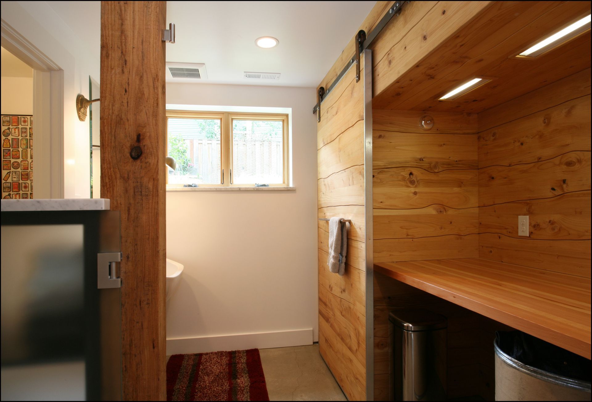 Small hallway with wood-paneled cabinets, a window, and a countertop with a mini fridge.