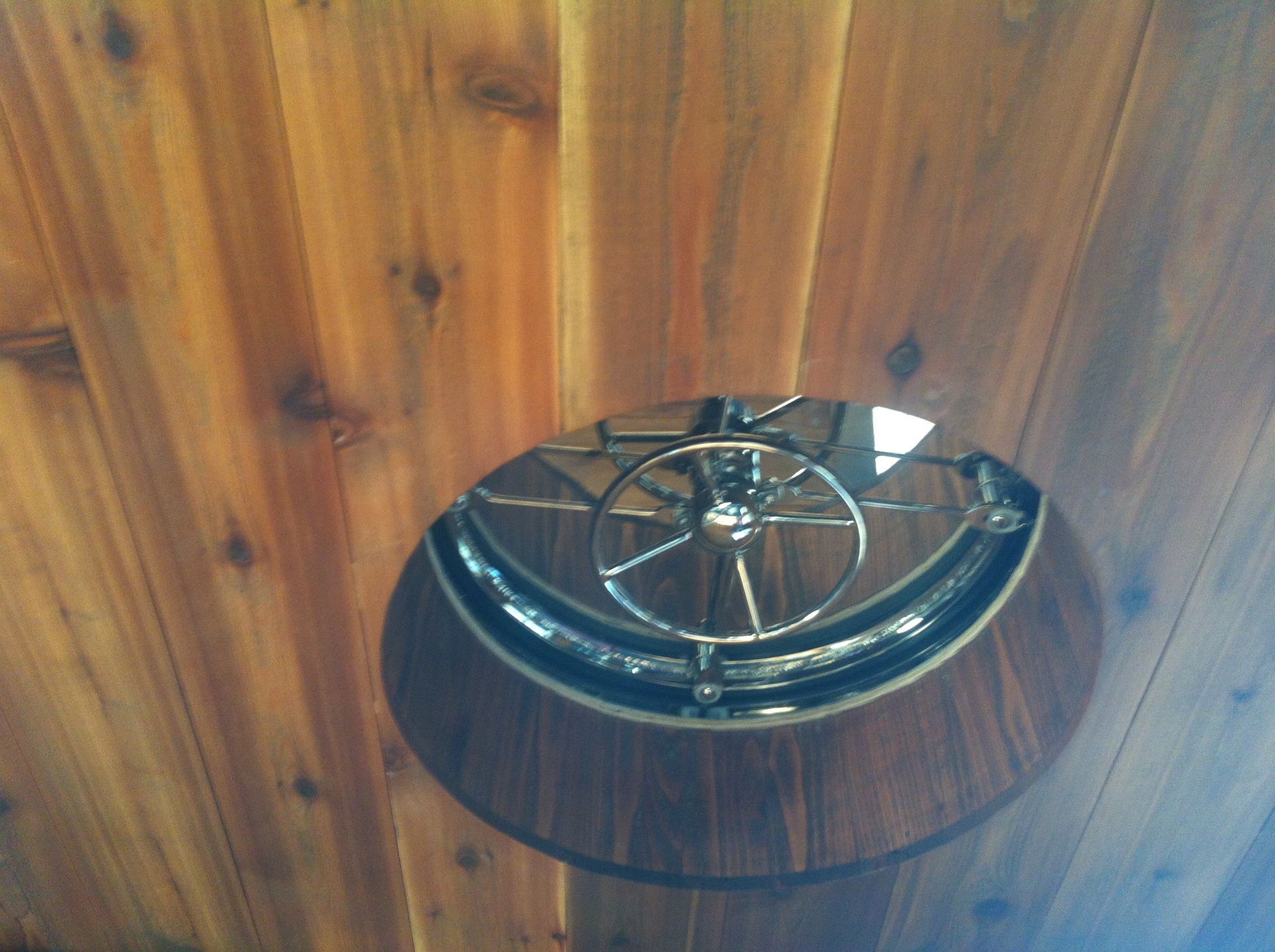 Wooden ceiling with a round recessed chrome light fixture centered in it