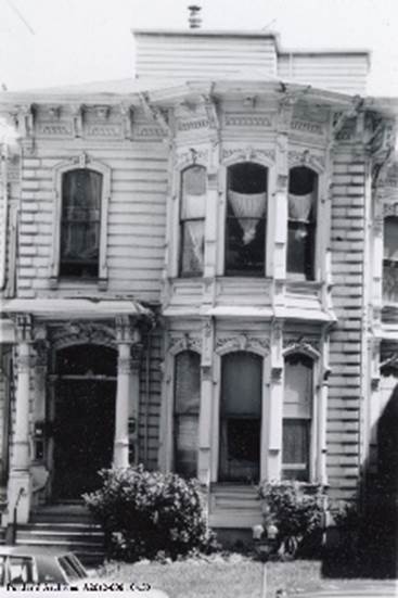 A black and white photo of a house with many windows