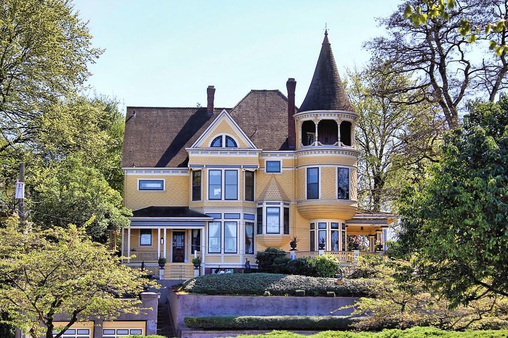 A large yellow house with a tower on top of it