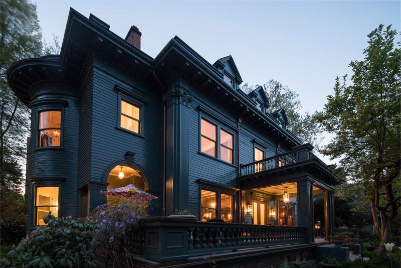 A large house with a lot of windows is lit up at night.