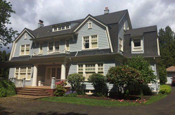 A large house with a black roof and white trim