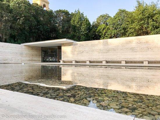 There is a large pool of water in front of a building.