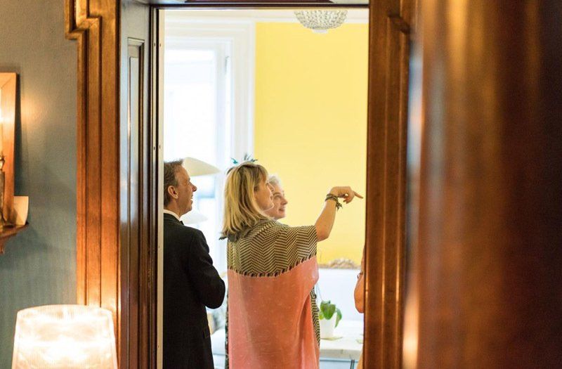 A man and a woman are standing in a doorway in a room.