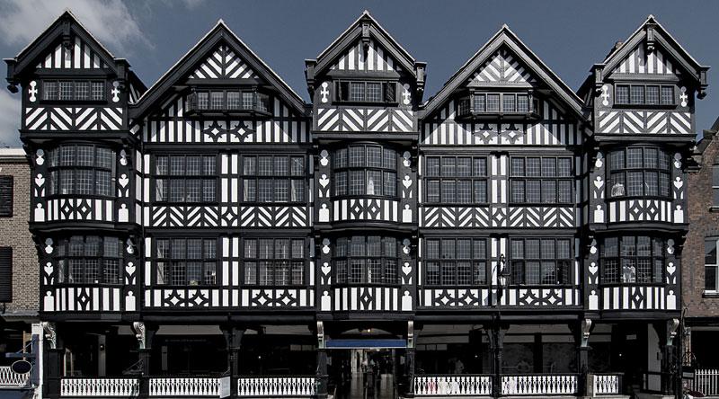 A row of black and white buildings with a blue sky in the background