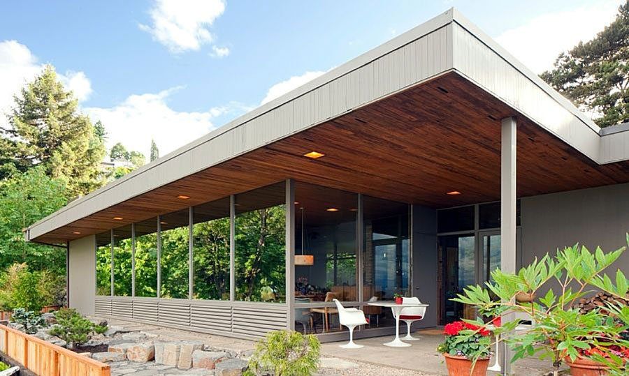 A modern house with a wooden roof and lots of windows