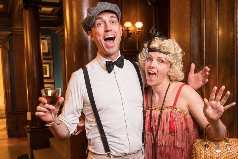 A man and a woman dressed in flapper costumes are posing for a picture.