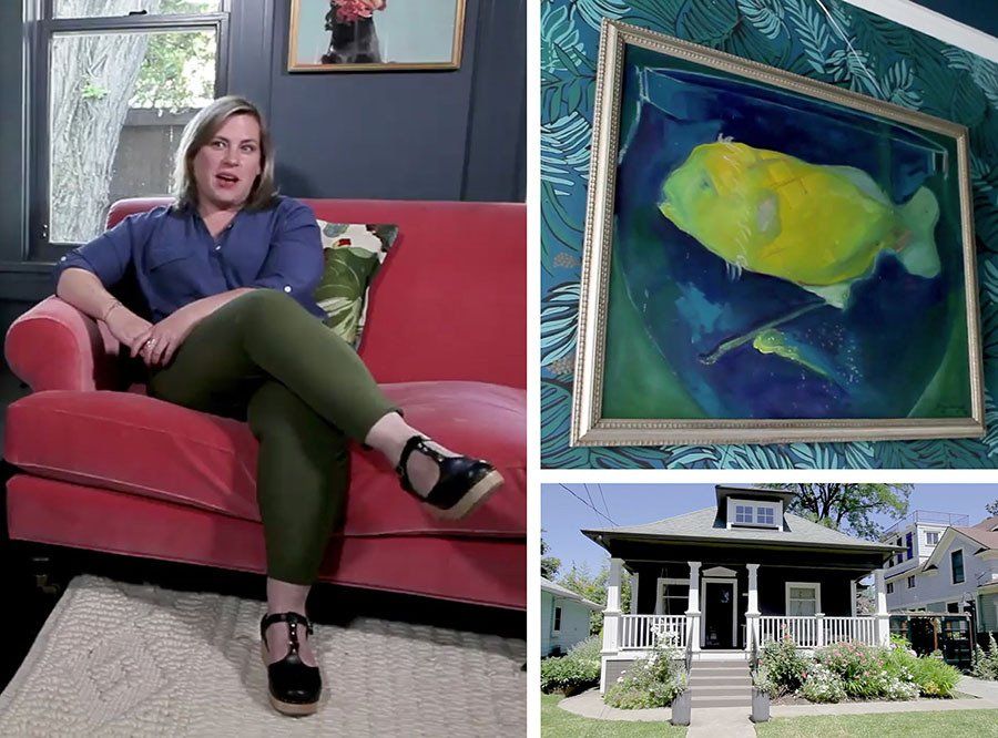 A woman is sitting on a red couch next to a picture of a fish and a house