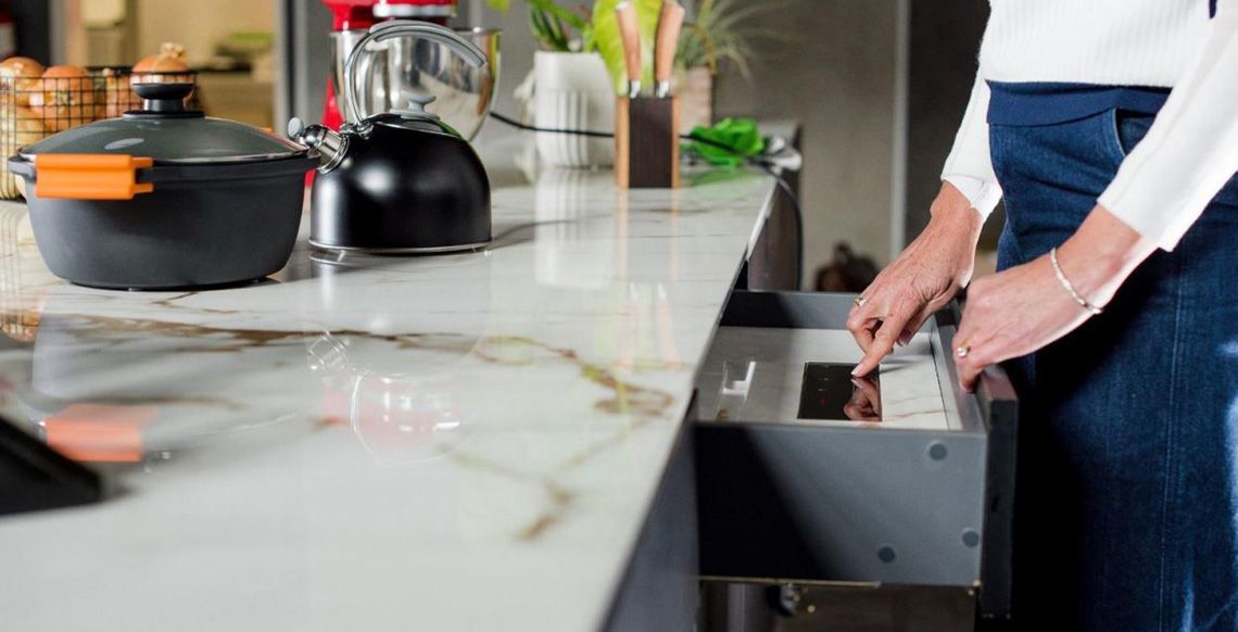 With an invisible induction cooktop the controls are in a drawer below the counter. Only certain surface materials have the conductivity to work with induction.