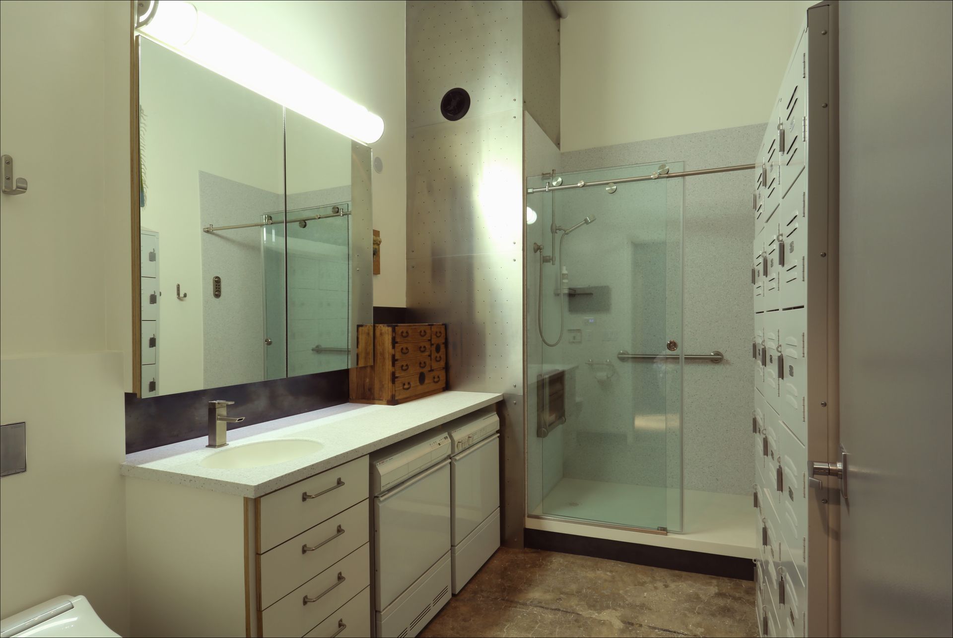 Modern bathroom with double vanity, large mirror, and glass-enclosed shower.