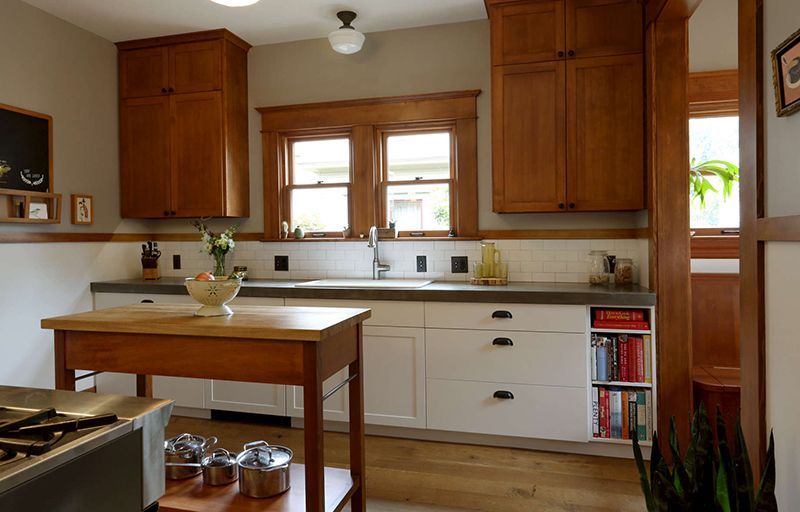 Bright kitchen with wooden cabinets, white counters, a center island, and a window above the sink.