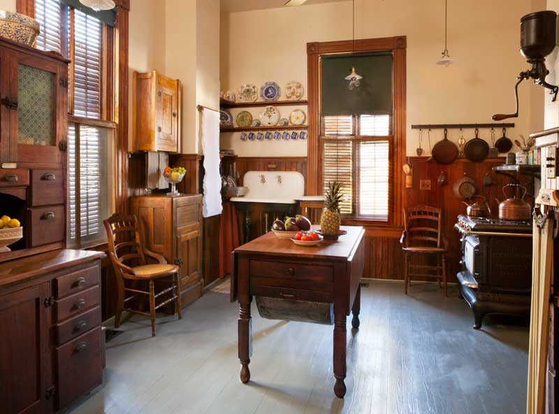 There is a desk and chair in the room with a lot of windows.