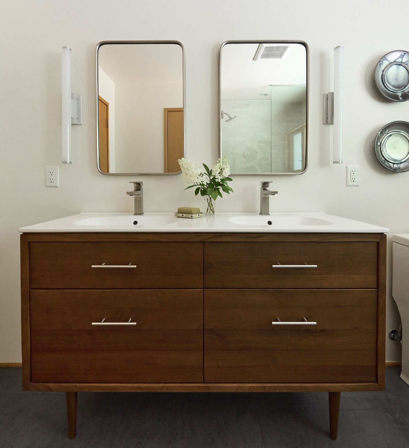 The guest bath has room for two with a double vanity in rich teak and a pair of medicine cabinets.