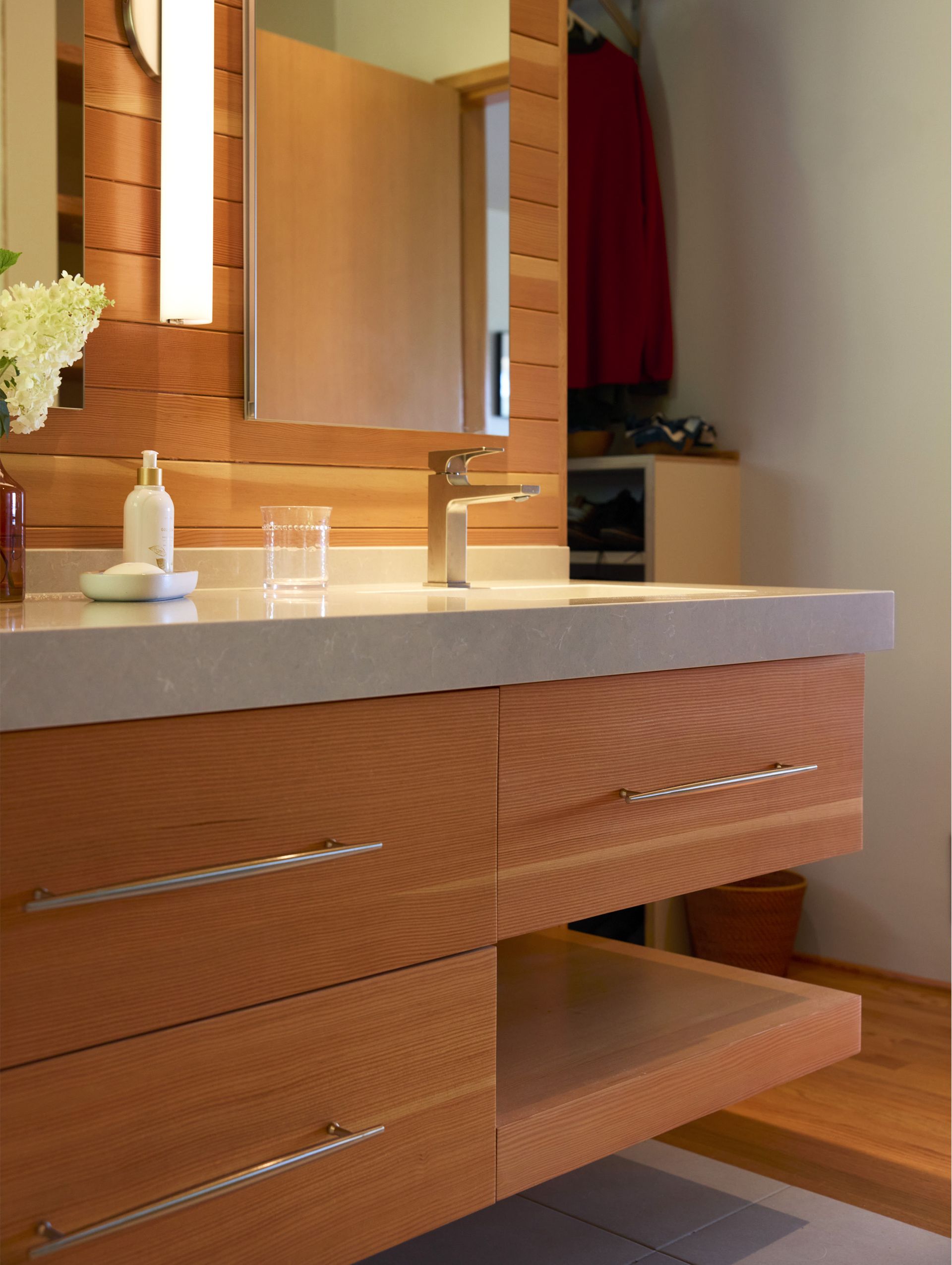 The fir, full overlay vanity was custom made with a top row of roomy drawers and a central bottom row drawer flanked by 3cm cantilevered open shelves on the outer edges.