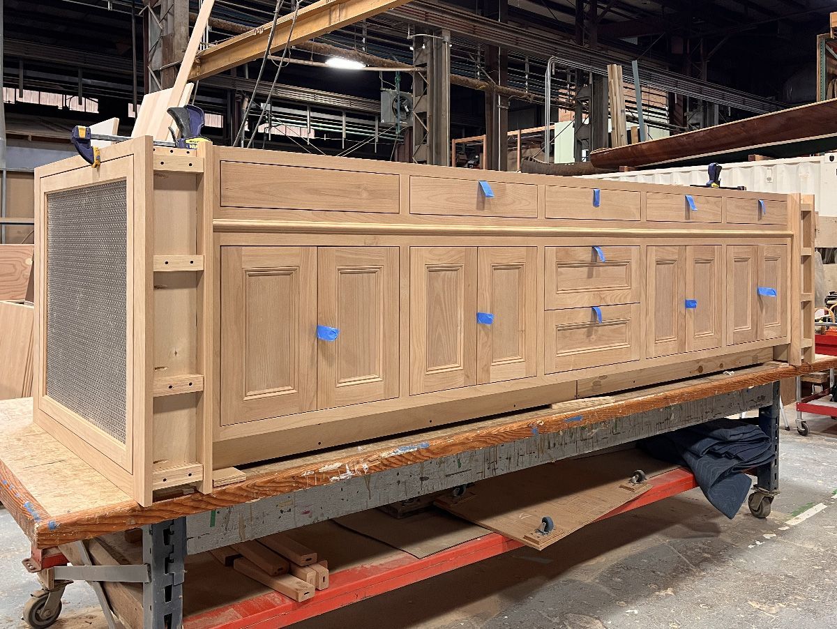 A large, period-inspired island for a Dunthorpe neighborhood kitchen under construction in the Arciform cabinet shop. The metal grilles at either end will hide traditional radiators. 