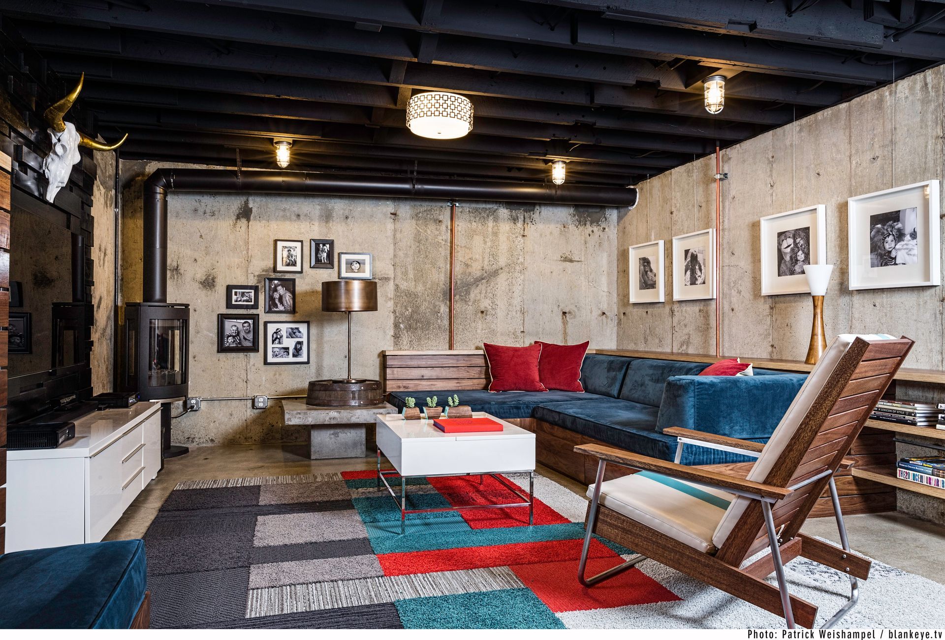 Modern living room with sectional sofa, armchair, coffee table, colorful rug, and framed wall art