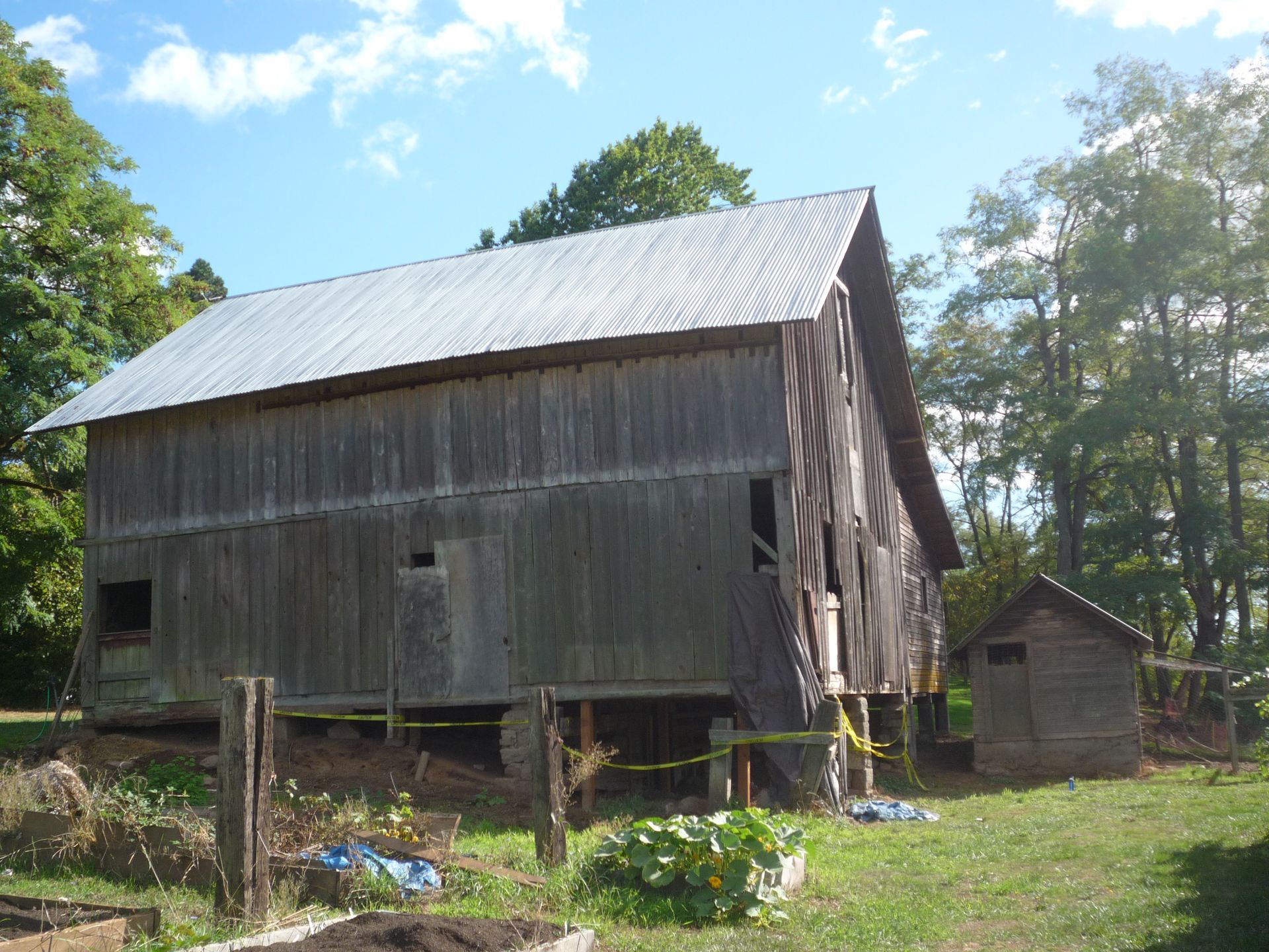 Old wooden barn with a metal roof in a grassy rural setting