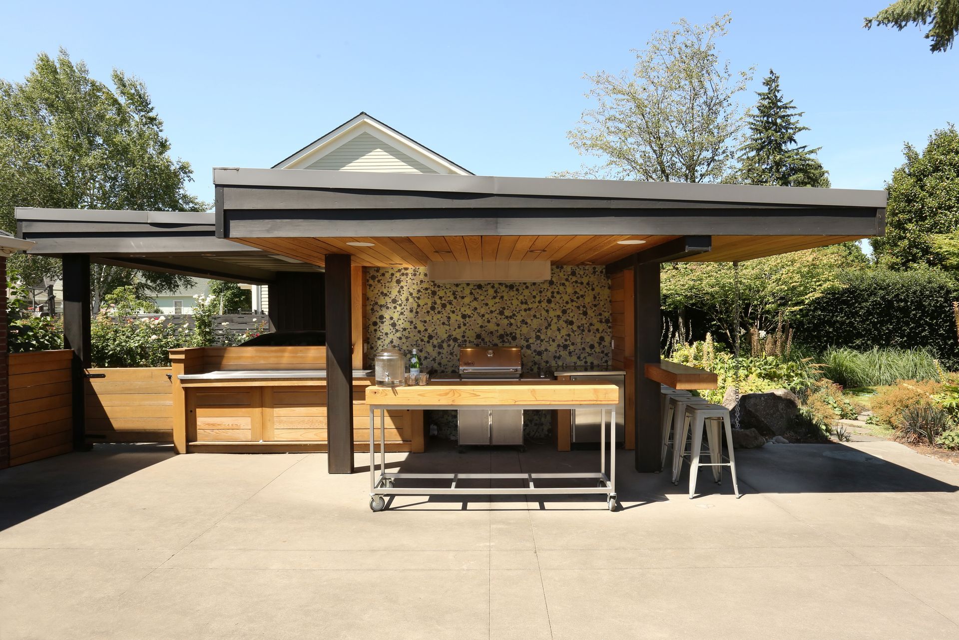 Wide view of the covered outdoor kitchen with horizontal emphasis and wood slat paneling