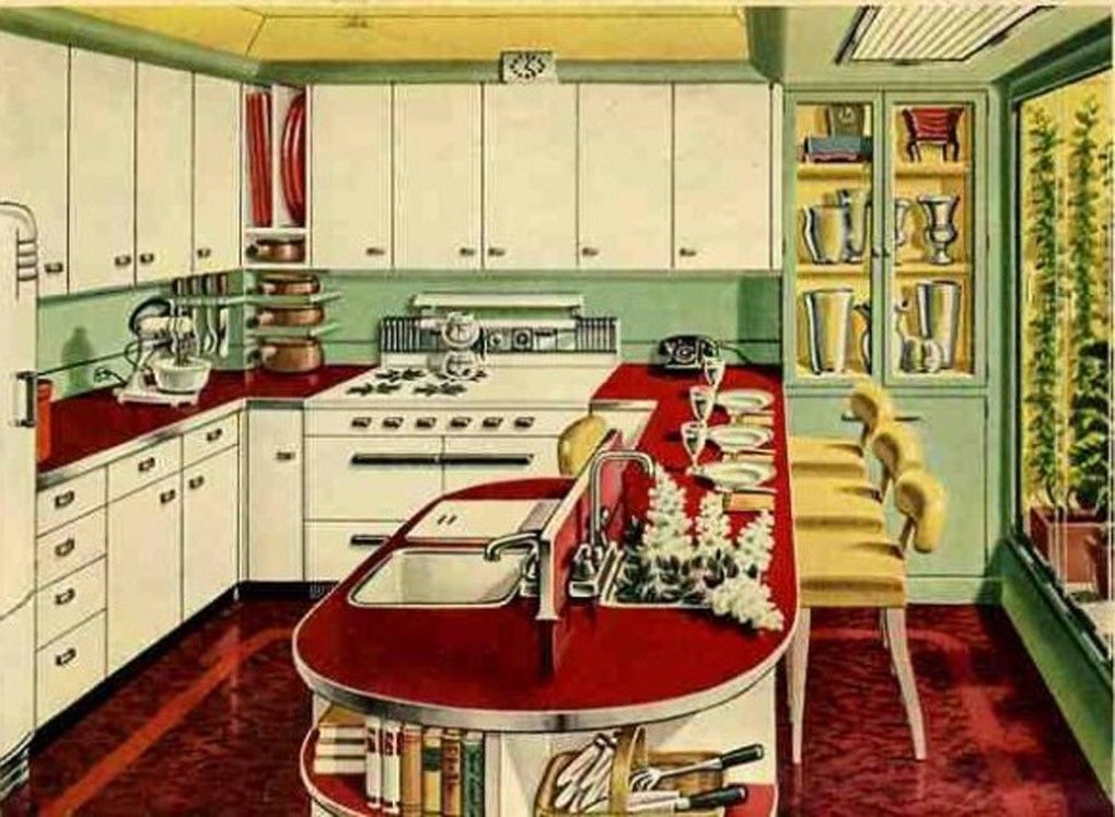 Retro kitchen with white cabinets, red countertops, and a central island with stools and dishes.