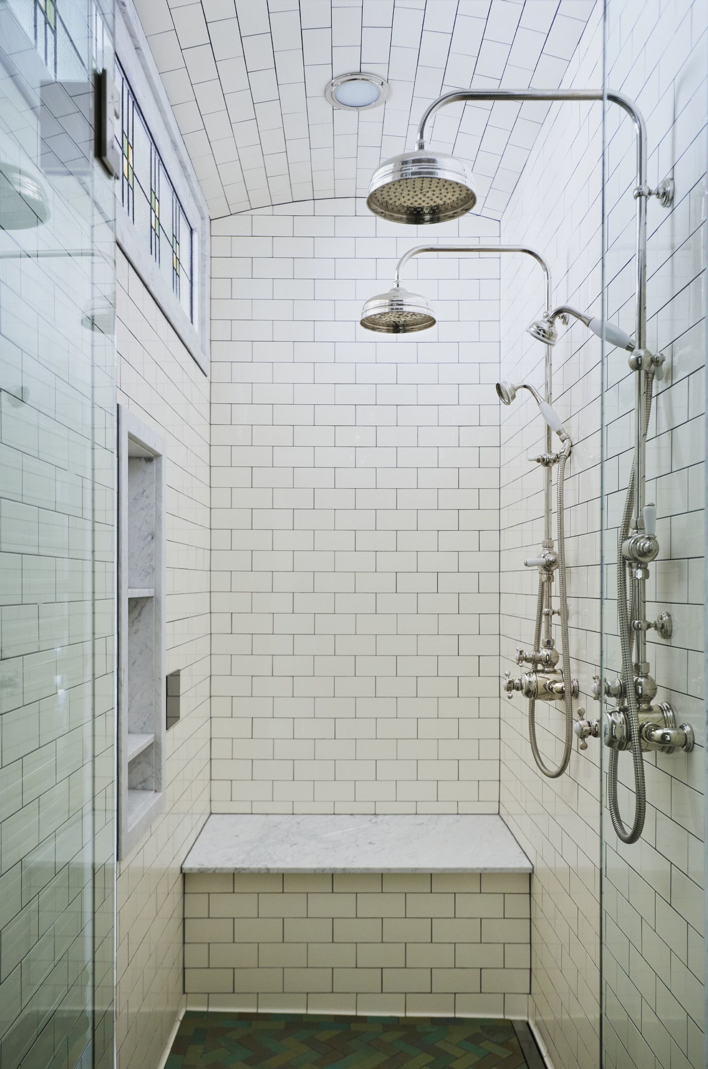 A steam shower for two with barrel-vaulted ceiling and a handy  bench for shaving in back. 