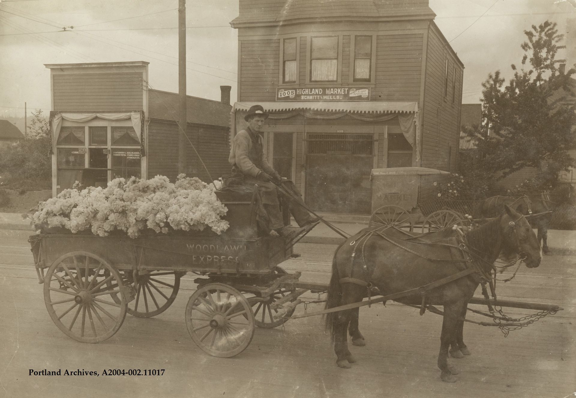 An early 20th century photo of the Woodlawn Express delivery wagon, with the Highland Market in the background.