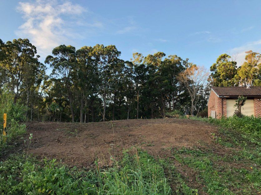 A Dirt Field With Trees and a Garage in the Background — Jeff Pearce Tree Services in Wauchope, NSW