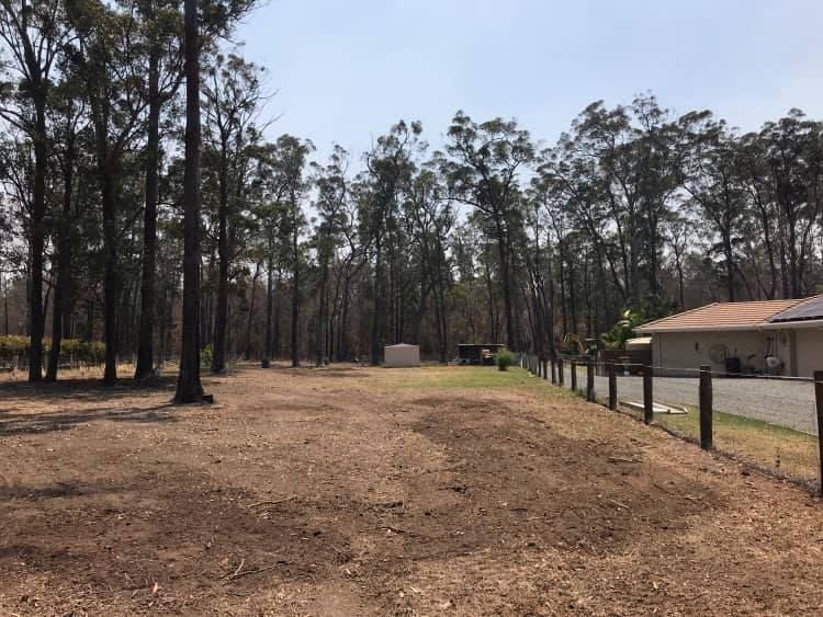 A House is Behind a Wooden Fence in the Middle of a Forest — Jeff Pearce Tree Services in Nabiac, NSW