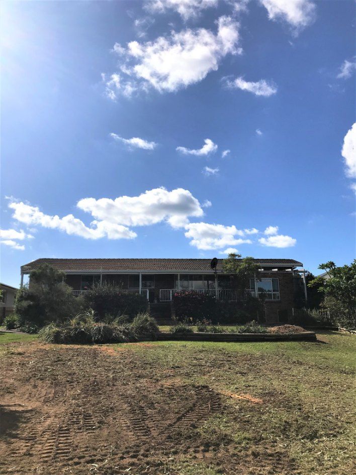 A Large House is Sitting in the Middle of a Field — Jeff Pearce Tree Services in Old Bar, NSW