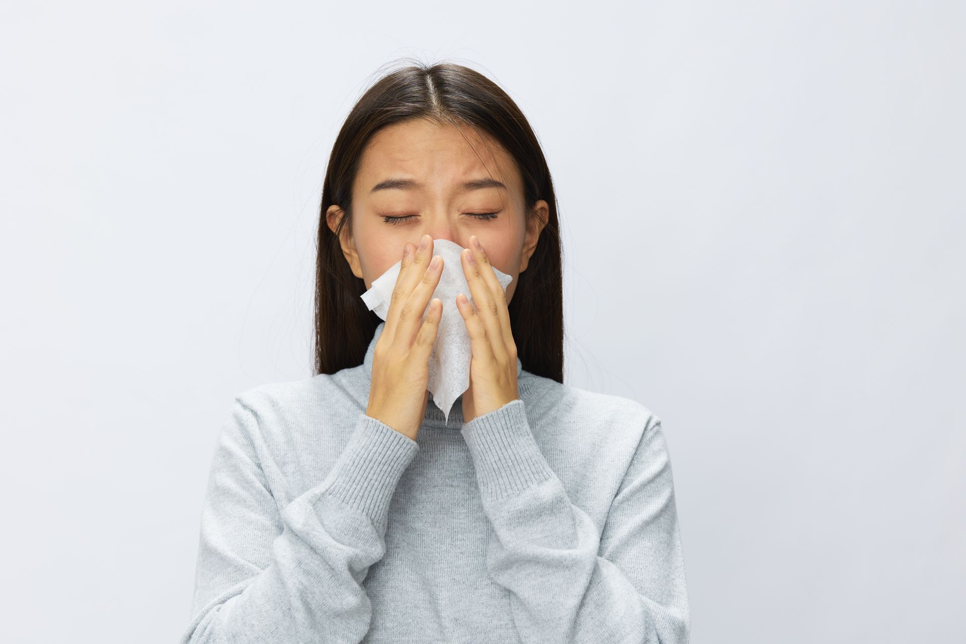 A woman is blowing her nose with a napkin.