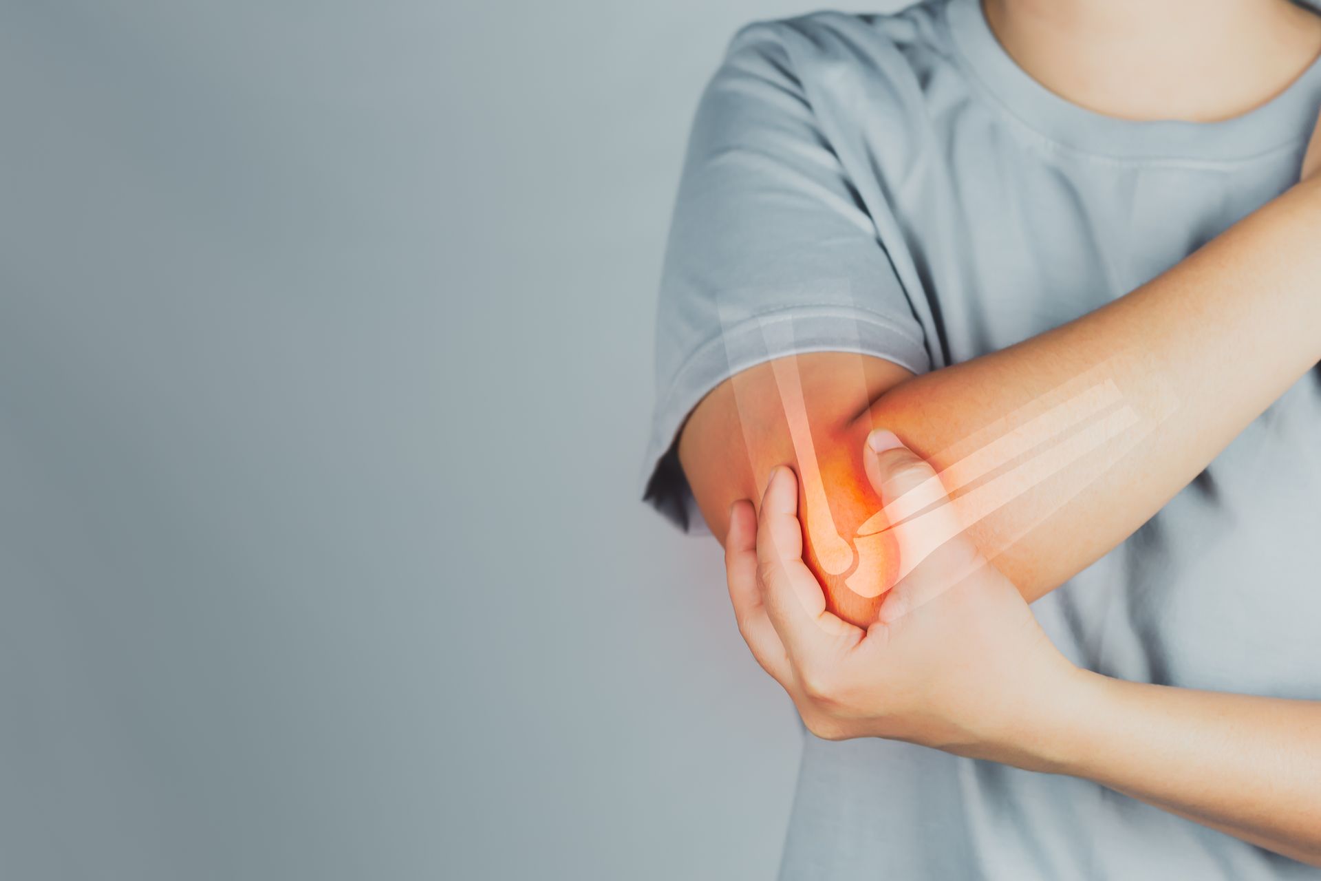 A woman is holding her elbow in pain.