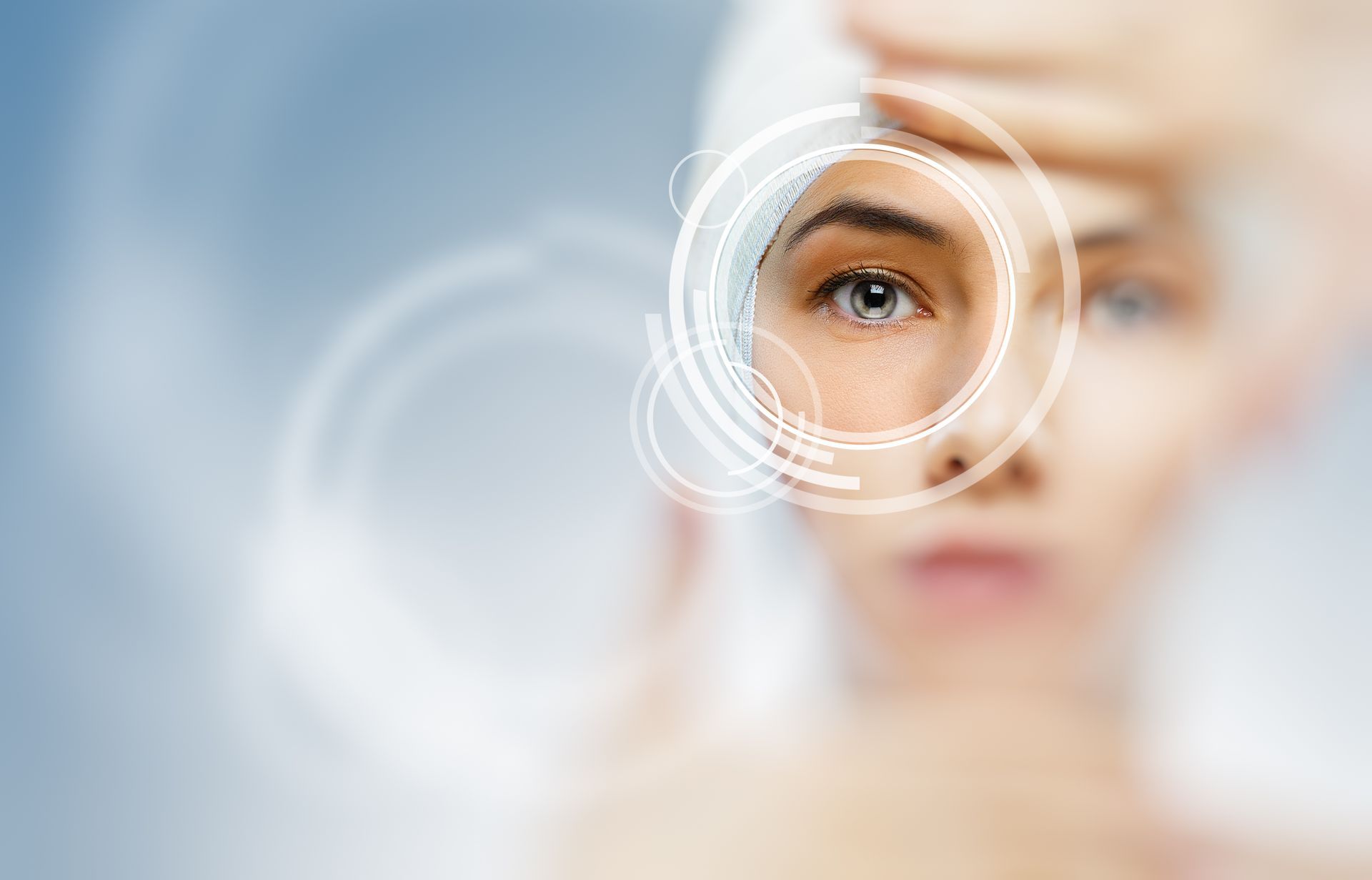 A woman is looking through a magnifying glass at her eye.