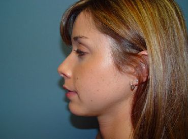A close up of a woman 's face with long hair and earrings.